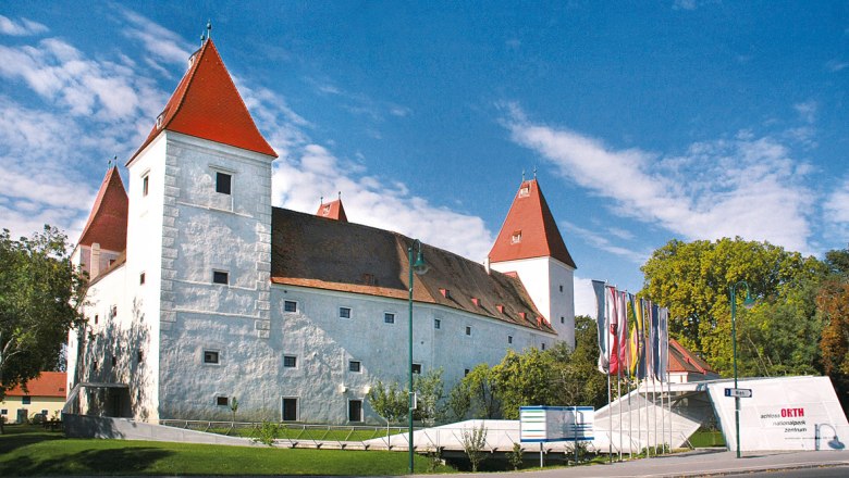 Nationalpark Donau-Auen, Schloss Orth an der Donau, © Kern Schloss Orth mit roten Dächern und Fahnen im Vordergrund.
