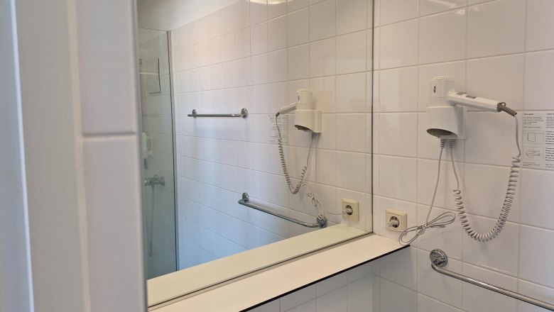 Badezimmer, © smart concept team gmbh Modernes Badezimmer mit Spiegel, Haartrockner und Handtuchhalter.