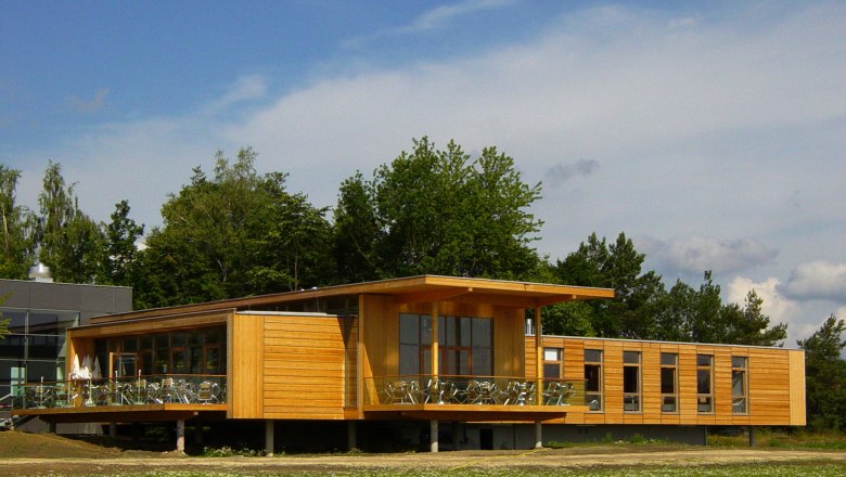 National Park House, © Nationalpark Thayatal Modern wooden building with large windows and terrace, surrounded by trees.