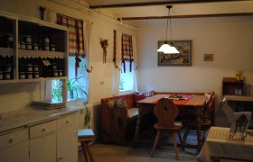 Ferienwohnung, © Fam. Pointner Gemütliche Küche mit Holzmöbeln und karierten Vorhängen.
