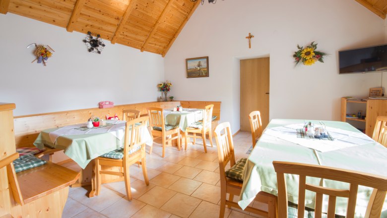 Breakfast room, © Winzerhof Semmler Cozy room with wooden furniture and decorated tables.
