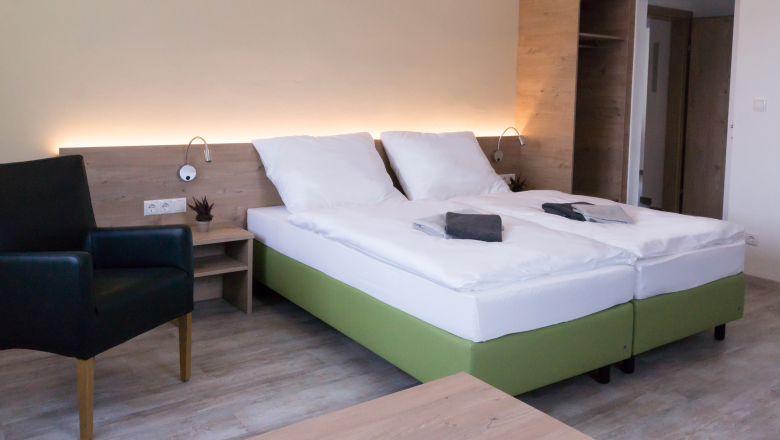 Familienzimmer, © W. Garhöfer Modern eingerichtetes Hotelzimmer mit Doppelbett, Nachttisch, Sessel und Kleiderschrank.