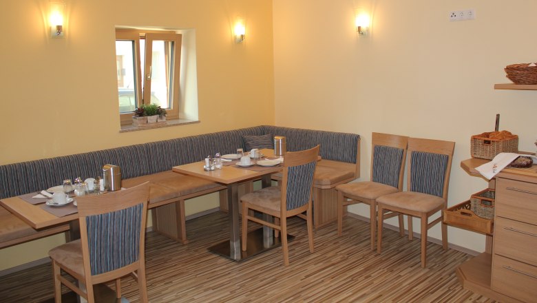 Gästehaus Woditschka, © Fam. Woditschka Gemütlicher Frühstücksraum mit Holzmöbeln und gedecktem Tisch.