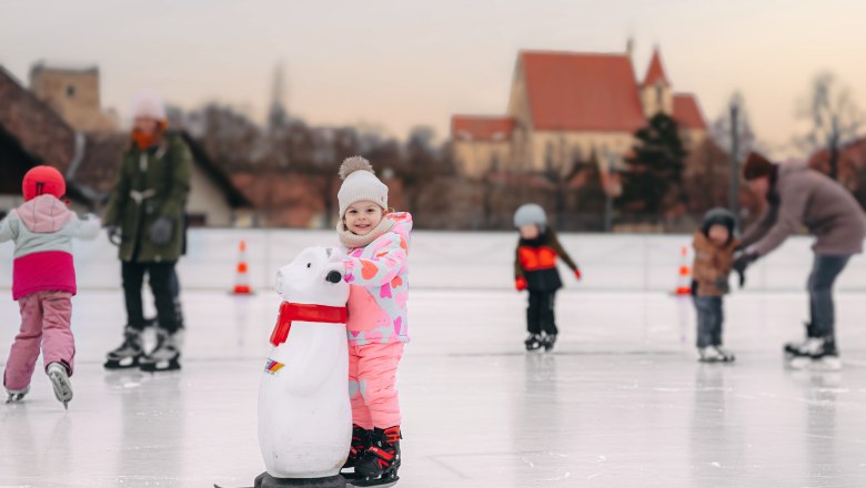 Eislaufplatz in Eggenburg, © Martin Mathes Kinder beim Eislaufen auf einem Platz mit einer Kirche im Hintergrund.