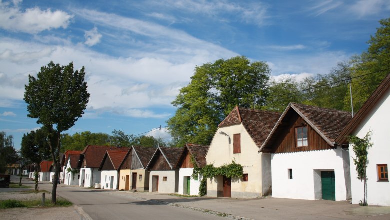 Kellergasse Jetzelsdorf, © Andreas Sedlmayer Reihe von traditionellen Weinkellern in Jetzelsdorf unter blauem Himmel.