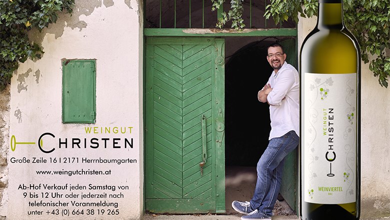 Weingut Christen, © Weingut Christen Ein Mann lehnt an einer grünen Tür neben einer Weinflasche mit dem Etikett 'Weingut Christen'.