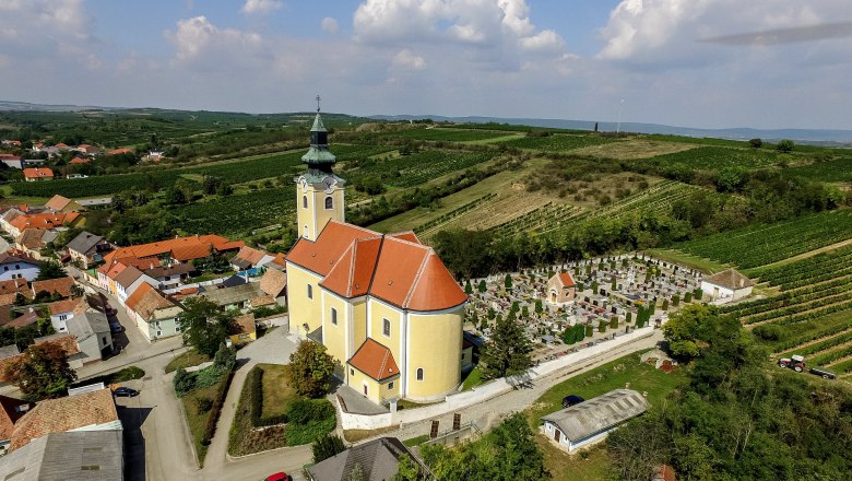 Pfarrkirche in Röschitz, © Marktgemeinde Röschitz Luftaufnahme der Pfarrkirche in Röschitz mit umliegendem Friedhof und Weinbergen.