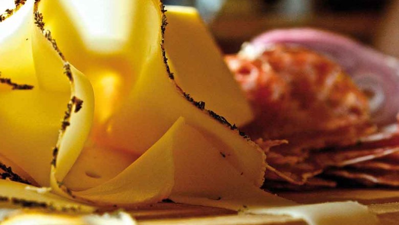 Food, © Egle Close-up of thinly sliced cheese and sausage on a wooden board.