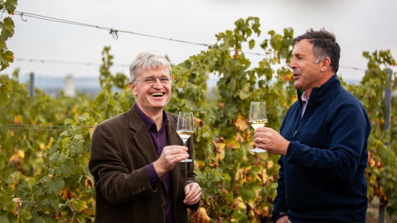 A well-rehearsed team: Maximilian Hardegg and his winery manager Andreas Gruber, © Florian Smetana Two men clink glasses in a vineyard.