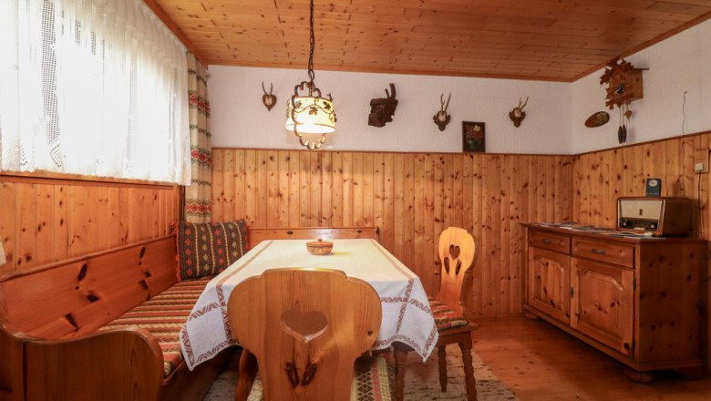 Cozy parlor in the cellar, © Novasol / Fam. Schachner Cozy cellar room with wooden furniture, corner bench, table, radio and hunting trophies on the wall.