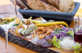 Heurigenjause, © Weinviertel Tourismus GmbH / Schwarz-König Heurigenplatte mit Aufschnitt, Zwiebeln, Gurken und Brot.