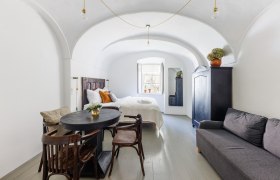 Gästezimmer, © Fam. Sebök Ein stilvoll eingerichtetes Gästezimmer mit gewölbter Decke, Bett, Sofa, Tisch und Stühlen. Ein Fenster lässt Tageslicht herein.