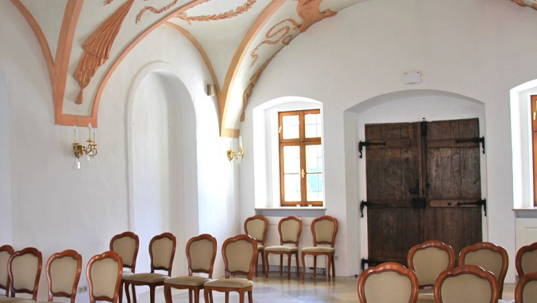 Belvedereschlössl/Bezirksmuseum Stockerau, © Stadtgemeinde Stockerau Innenansicht eines historischen Raumes mit verzierten Stuckdecken und eleganten Holzstühlen.