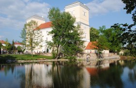 Schloss Wolkersdorf, © Stadtgemeinde Wolkersdorf Schloss Wolkersdorf mit Teich im Vordergrund und Bäumen im Hintergrund.