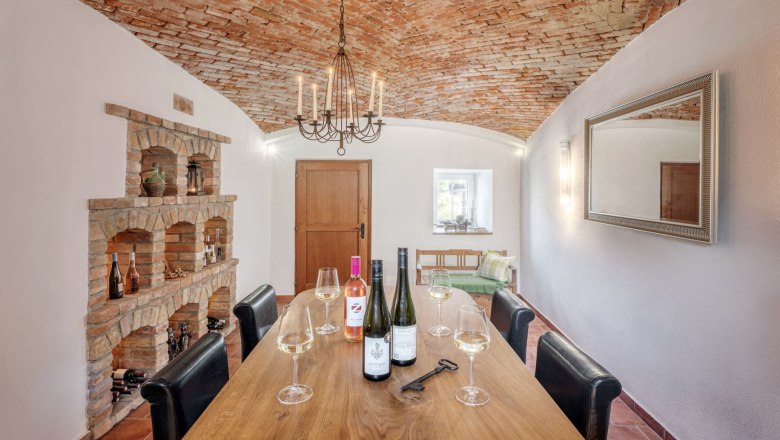 Beautiful ambience for wine tastings, © Martin Sommer Cozy wine cellar with brick vault, wooden table, wine glasses and bottles.