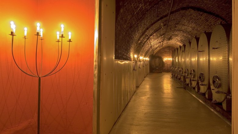 Keller, © Petr Blaha Weinkeller mit beleuchteten Metalltanks und Kerzenleuchtern.