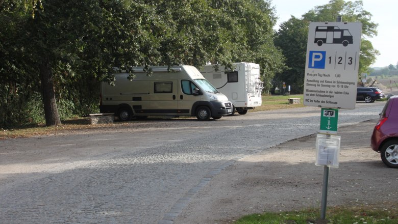 Motorhome parking space, © Hans Huysza Motorhome parking area with two parked motorhomes and a sign.