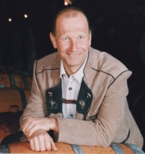 Winemaker, © Fam. Woditschka A man in traditional dress leans against a wine barrel.