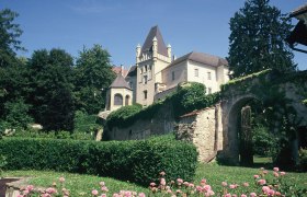 Schloss Maissau, © Weingut Ewald Gruber Schloss Maissau mit Garten und Blumen im Vordergrund.