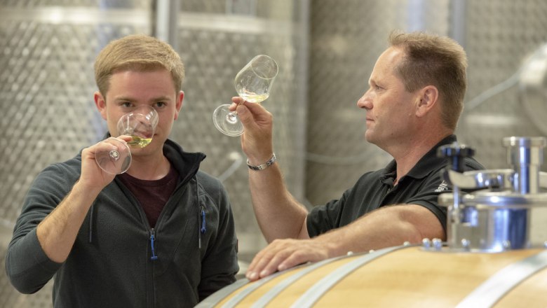 Weingut Heribert Wenzl, © Michael Himml Zwei Männer verkosten Wein in einem Weinkeller.