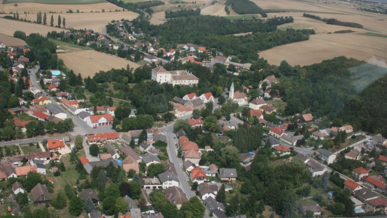 Blick auf Kreuzstetten, © Gemeinde Kreuzstetten Luftaufnahme von Kreuzstetten mit Feldern und Gebäuden.