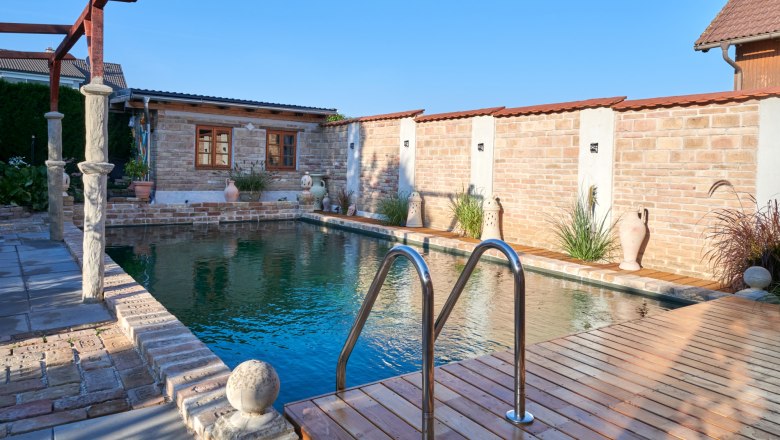 Refreshing cooling, © Michaela Wannemacher A small pool with a wooden deck and brick walls in the background.