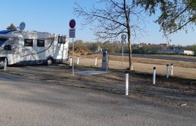 Wohnmobilstellplatz, © Stadtgemeinde Hollabrunn Wohnmobil auf einem Stellplatz mit Schildern und Bäumen.