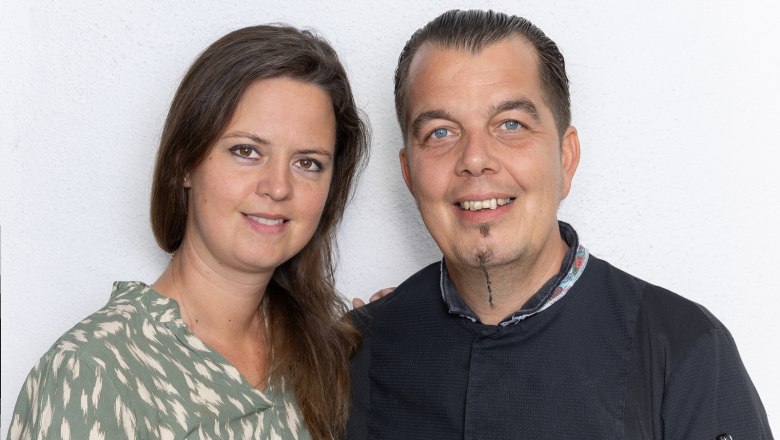 Verena and Christoph Schüller run the gourmet restaurant with great pleasure, © Josef Schimmer A man and a woman smile into the camera in front of a white background.