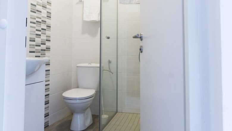 Bad und WC, © W. Garhöfer Modernes Badezimmer mit Toilette, Dusche und Handtuchhalter.