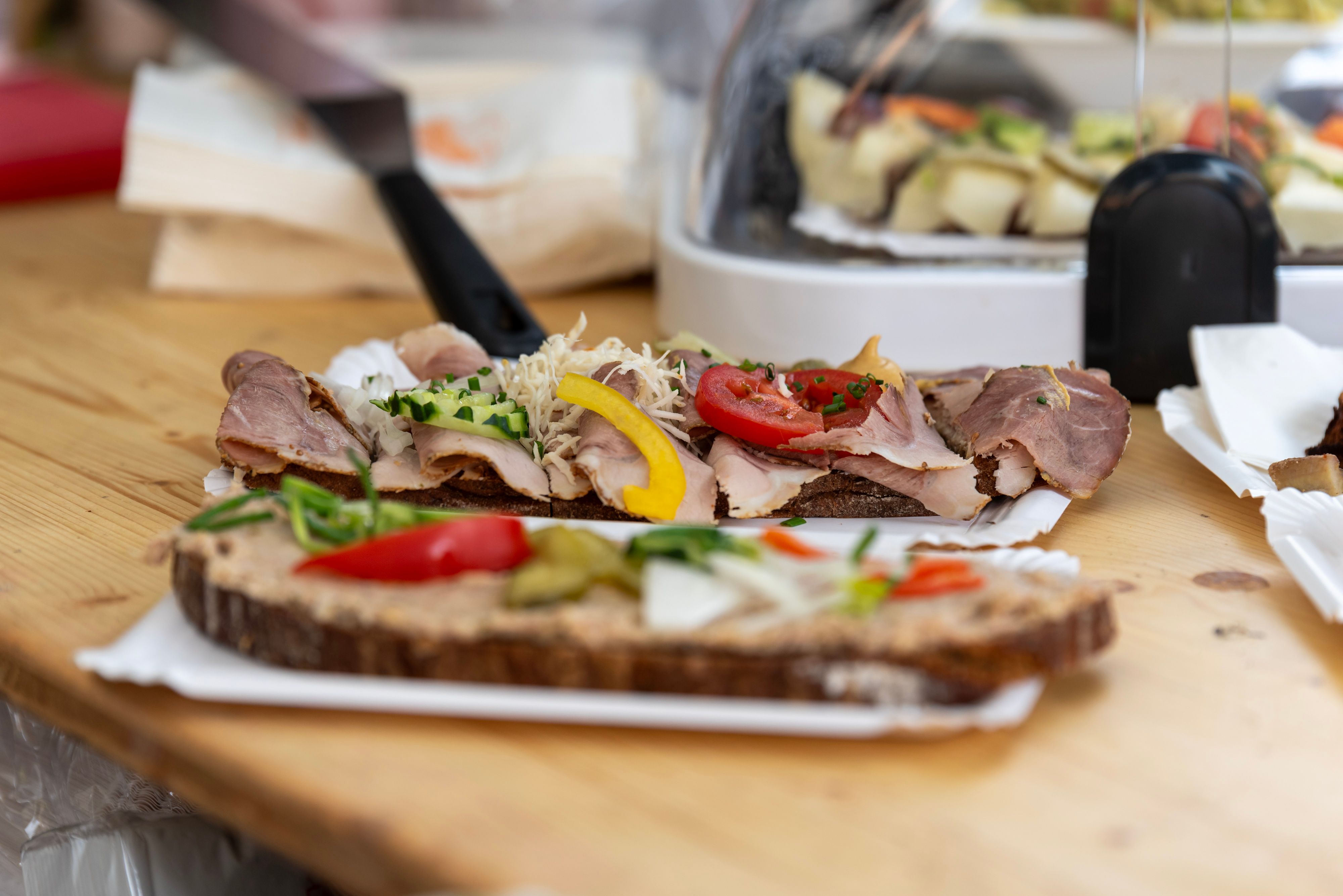 Klassische Heurigenbrote belegt mit Fleisch, Käse und Aufstrich liegen auf dem Tisch bereit zum Genießen. 