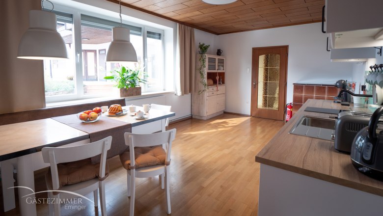 Moderne Wohnküche mit Esstisch, Stühlen und Küchenzeile.