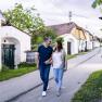 Ein Paar spaziert durch die Kellergasse in Zellerndorf, umgeben von traditionellen Weinkellern.