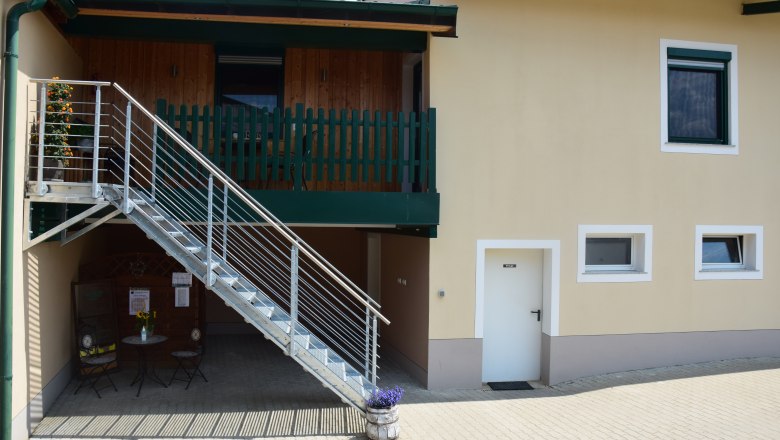 Au&szlig;enansicht eines Geb&auml;udes mit Treppe und Balkon.