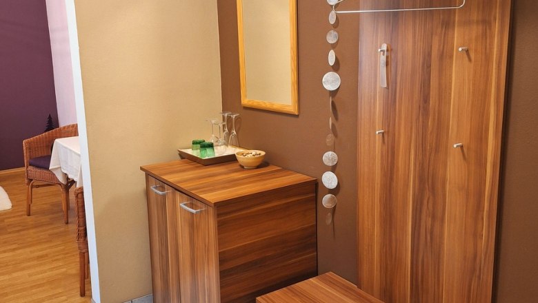 Moderner Eingangsbereich mit Holzmöbeln, Spiegel und Dekoration.