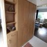 Wooden cupboard with shelves and drawers in one room.