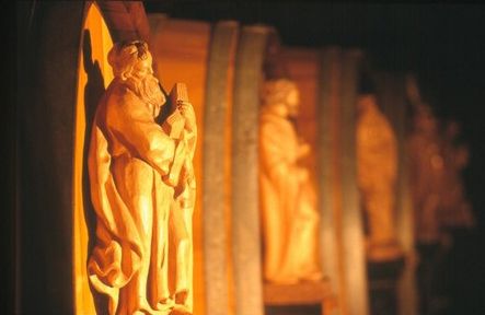 Wooden sculptures in warm light, arranged in a row.