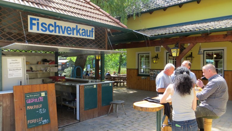 Ein Fischverkaufsstand mit Menschen, die an einem Tisch essen.