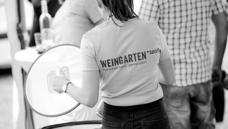 Woman in a T-shirt with the inscription 'Weingarten.rocks' at an event.