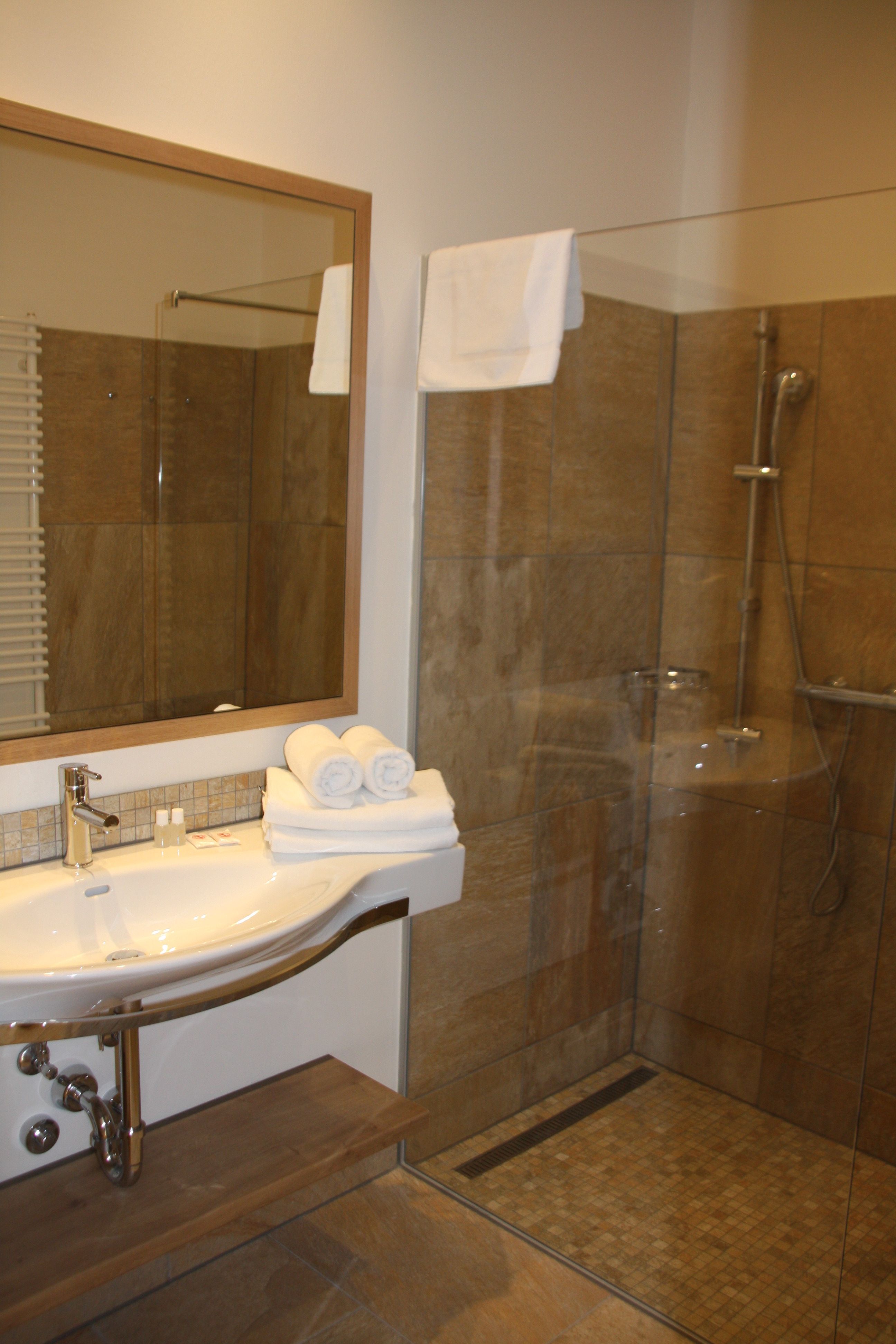 Modern bathroom with washbasin, mirror and shower.