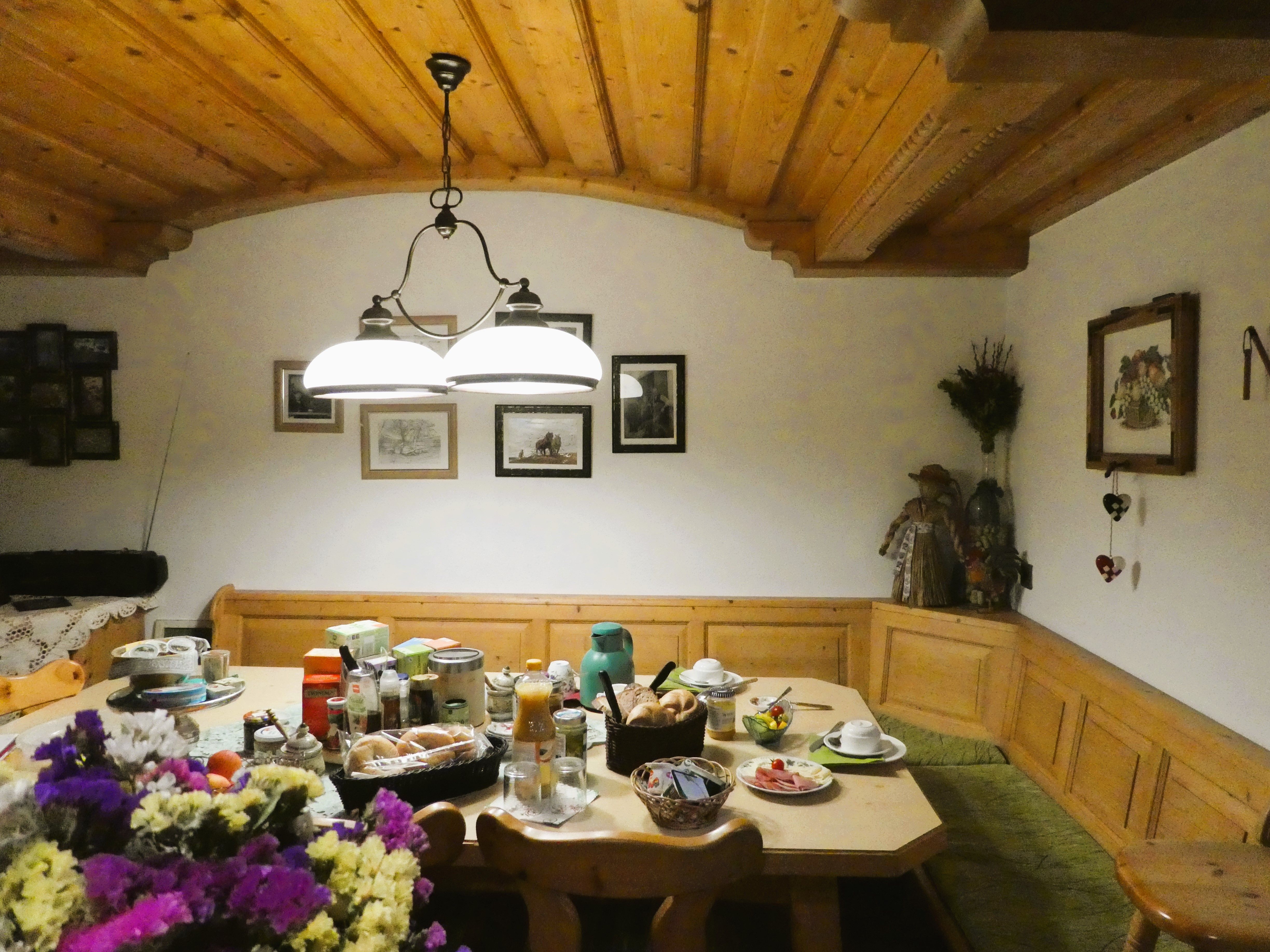 Gemütlicher Frühstückstisch in einem rustikalen Esszimmer mit Holzmöbeln und Dekorationen.