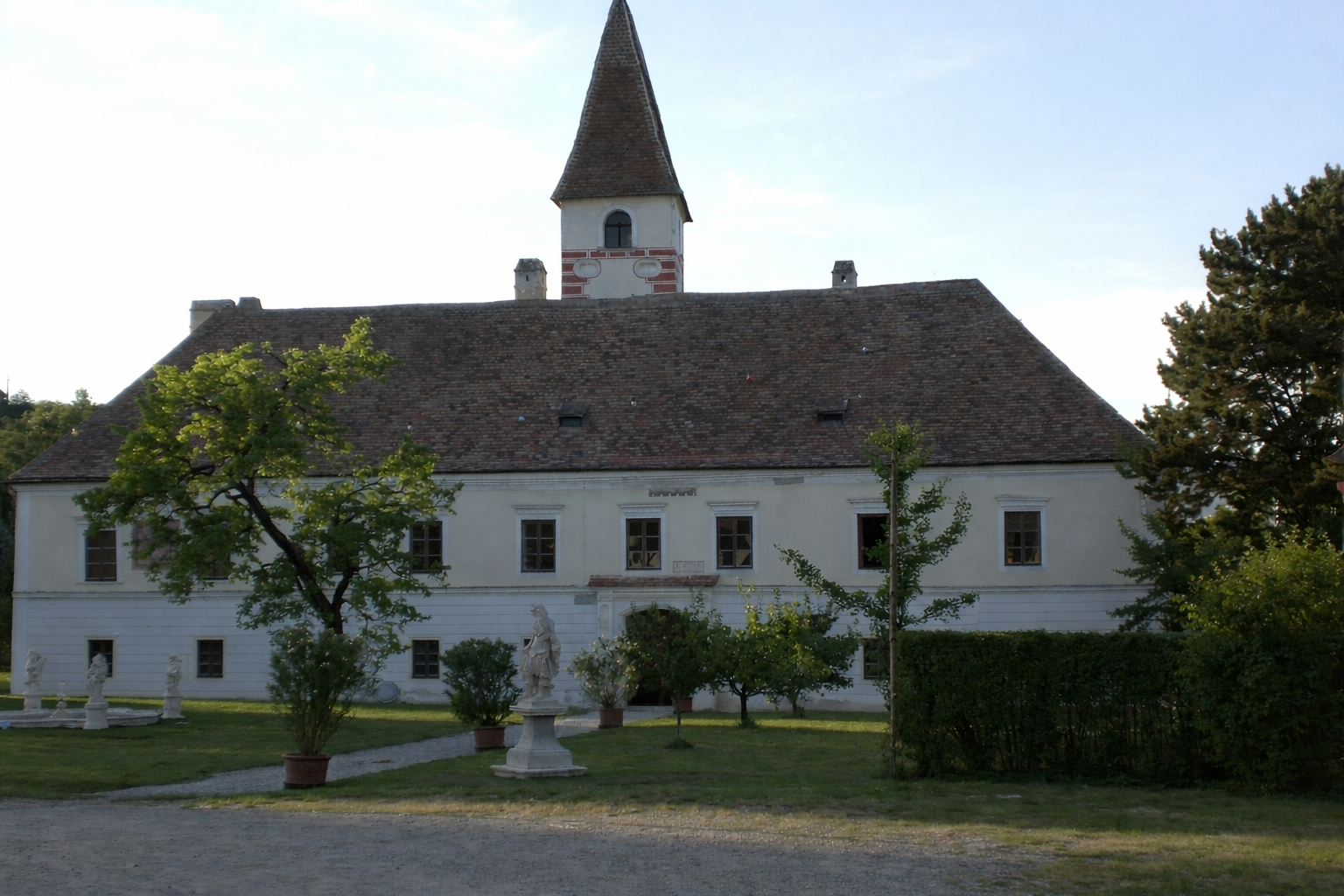 Schloss Limberg mit Garten und Statuen im Vordergrund.