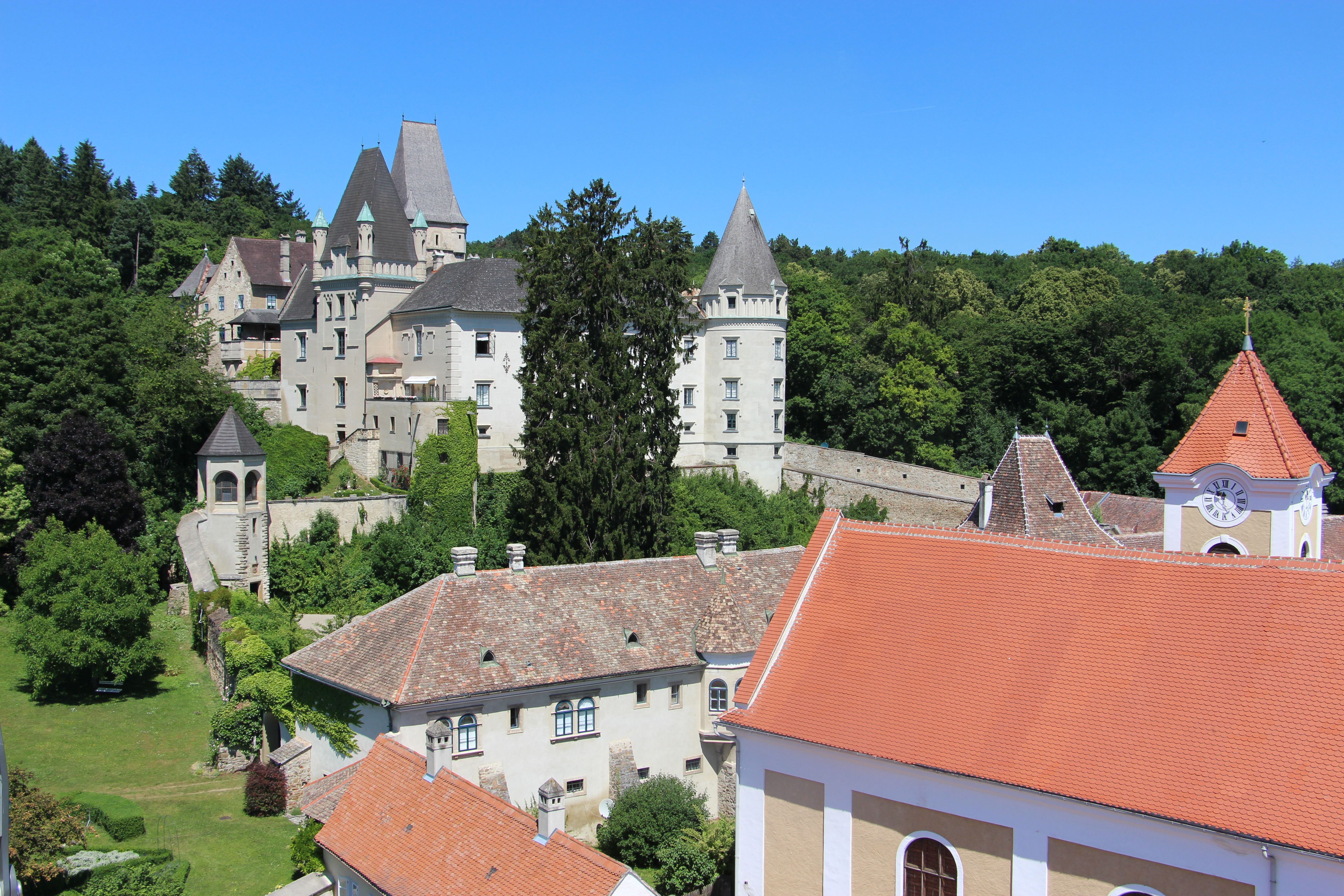 Maissau Castle with surrounding buildings and green landscape.
