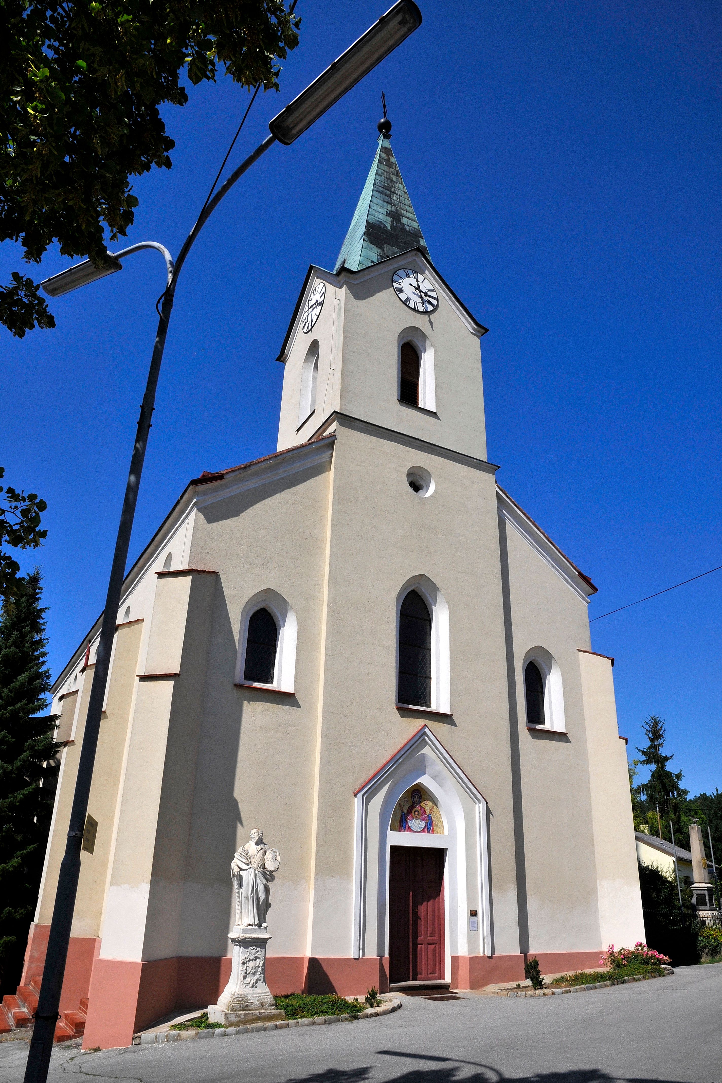 Church with tower and clock against a blue sky.