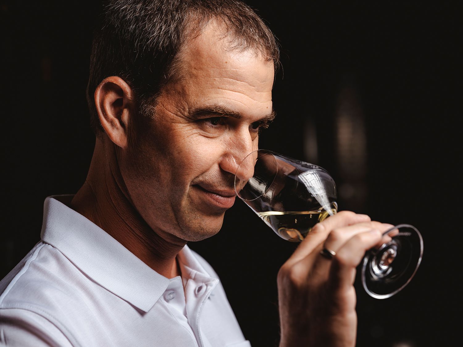 Person smells a glass of white wine.