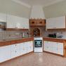 Kitchen with white and wood-colored cabinets, stove and sink.
