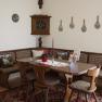 Traditional dining room with wooden furniture, corner bench and decorative wall plates.