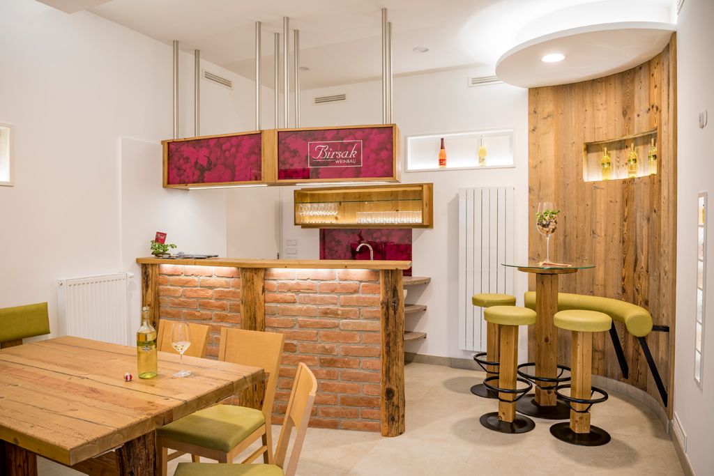 A modern tasting room with wooden furniture and a brick bar.