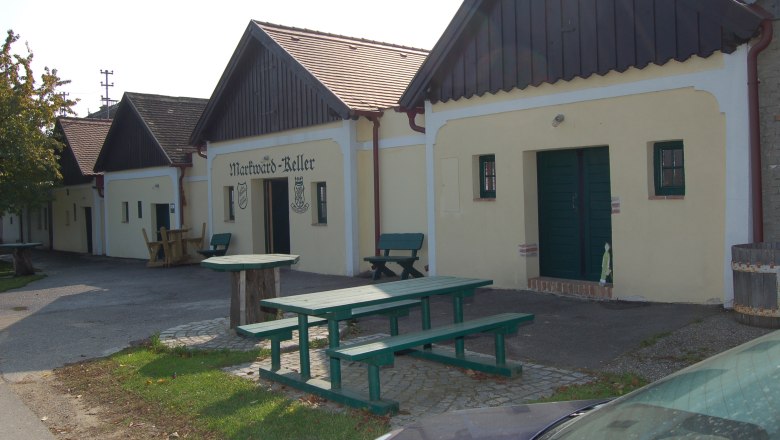 Exterior view of the Markward cellar with wooden benches and tables in front of it.