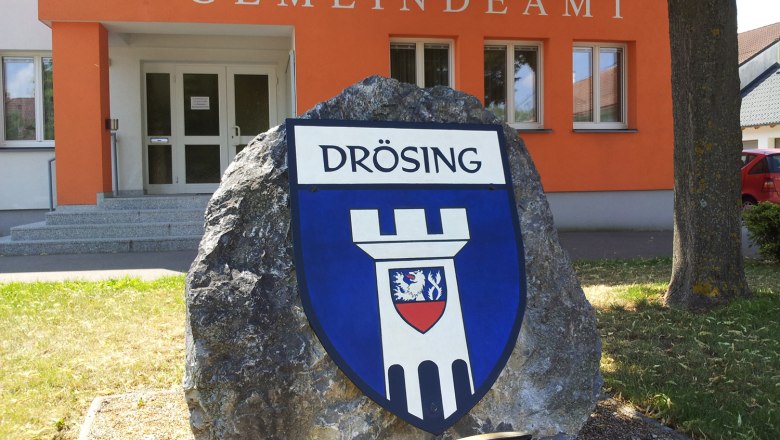 Eingang des Gemeindeamts Drösing mit Wappen auf einem Stein.