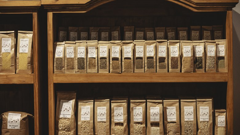 Shelf with various cereal and seed packets in a store.